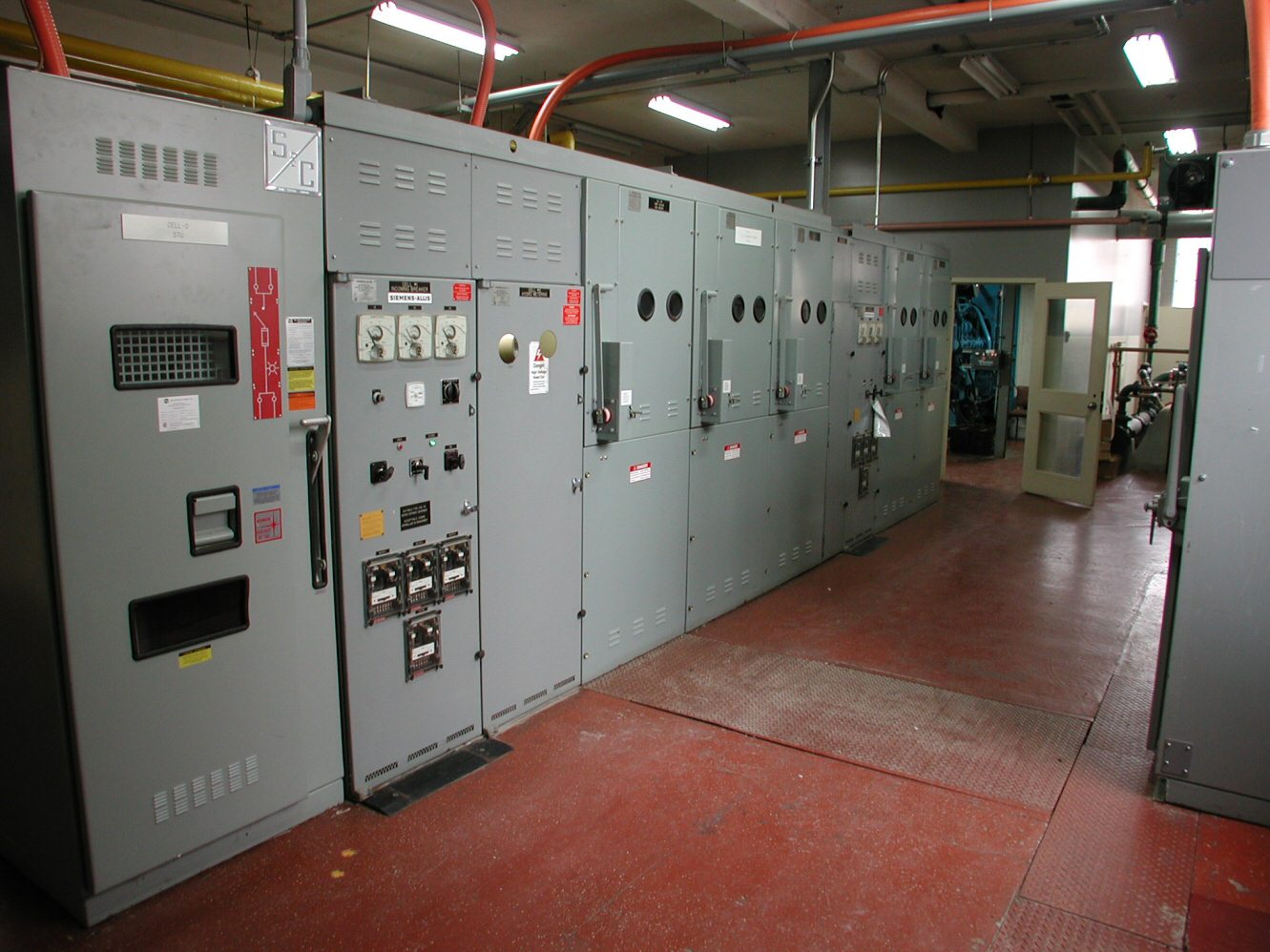 Main electrical distribution room with rows of commercial switchgear