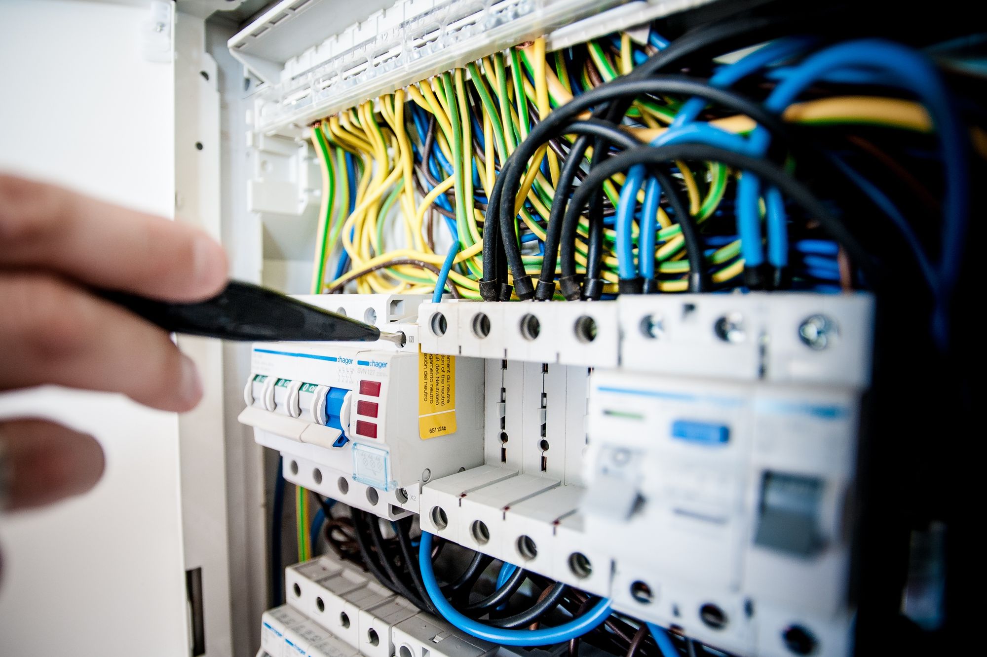 Electrician tightening a breaker in a commercial electrical panel